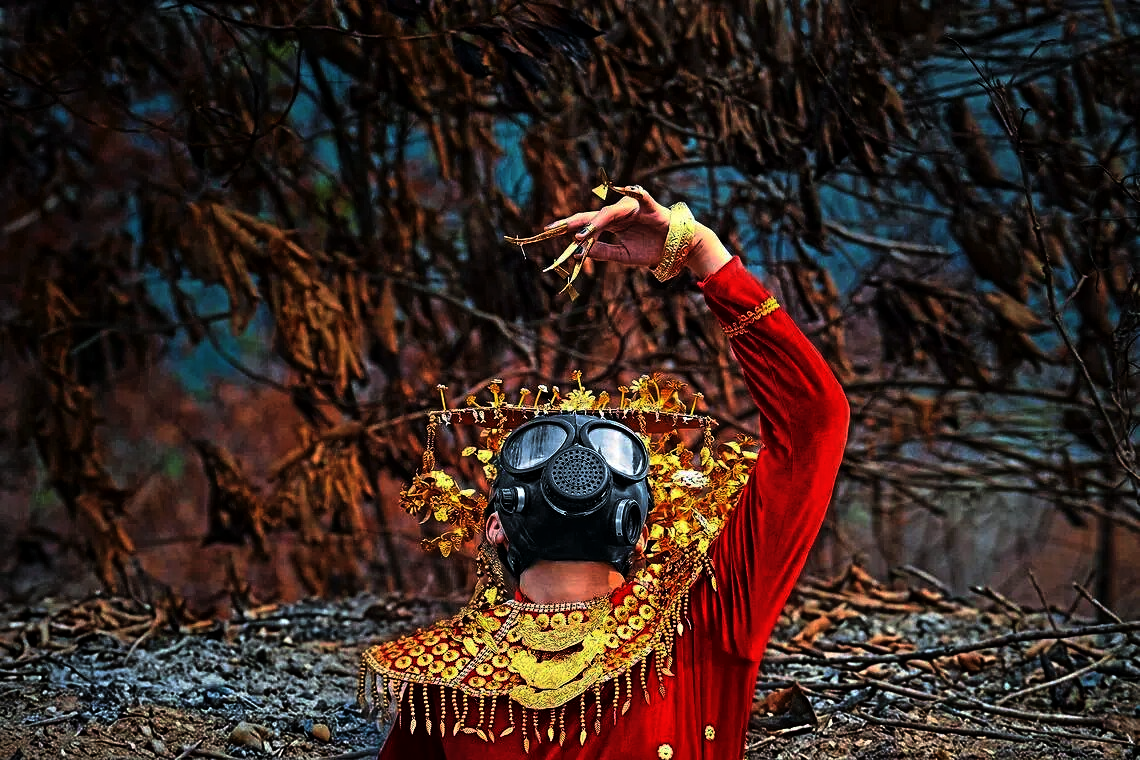 Breathtaking performance: A member of Zwageri Generation performing a traditional Dayak dance while wearing a gas mask on burnt peatland in Ketapang, West Kalimantan. — The Straits Times/ANN