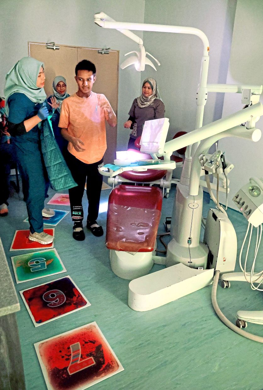 Numbers on the floor and dimmed lighting help create a calmer environment for Harith Rafael before his dental treatment.