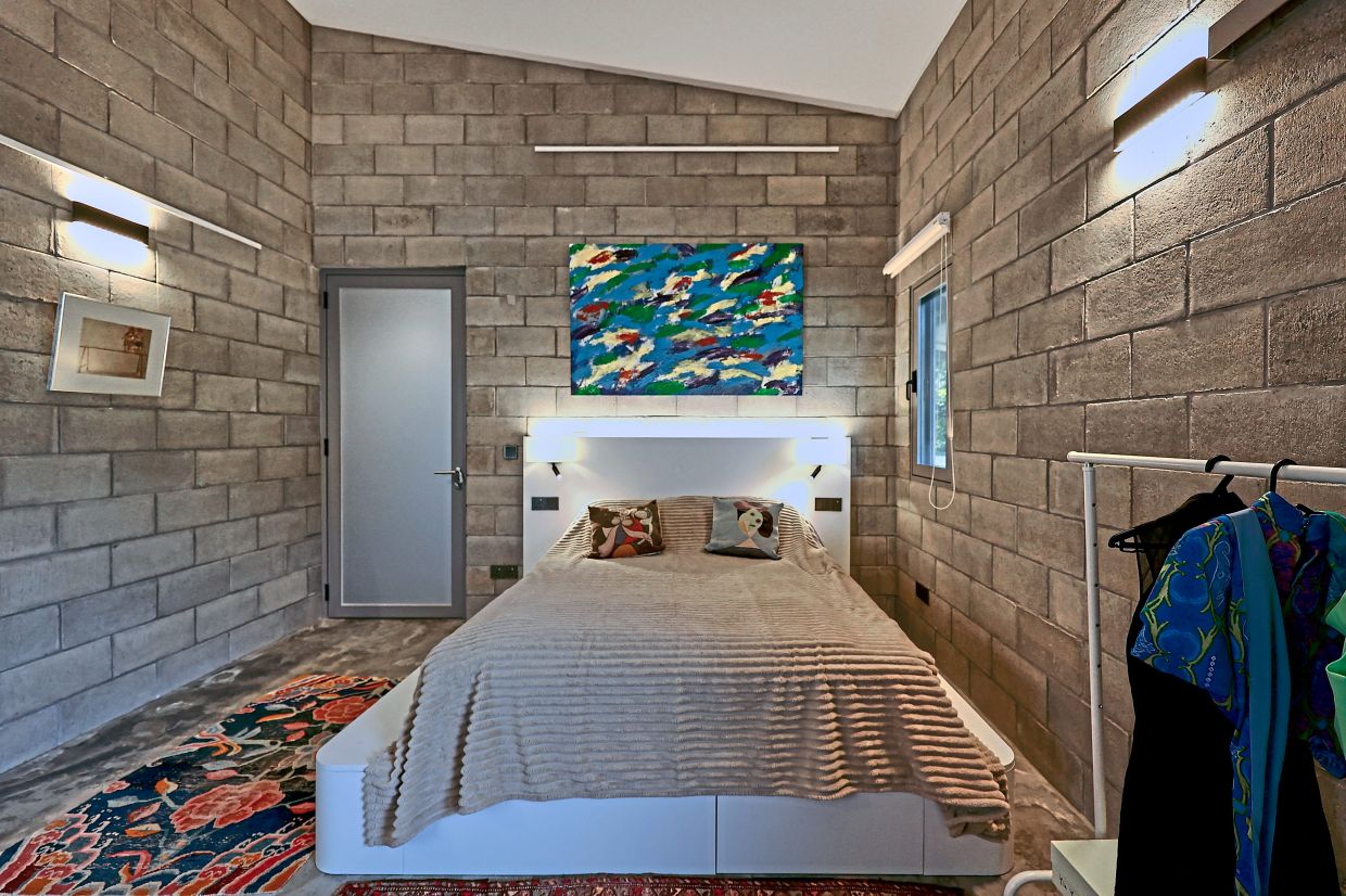 Natural concrete slabs in the bedroom give the home a rustic feel.