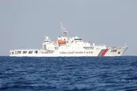 China's coast guard monitors the Philippines resupplying vessel at disputed shoal
