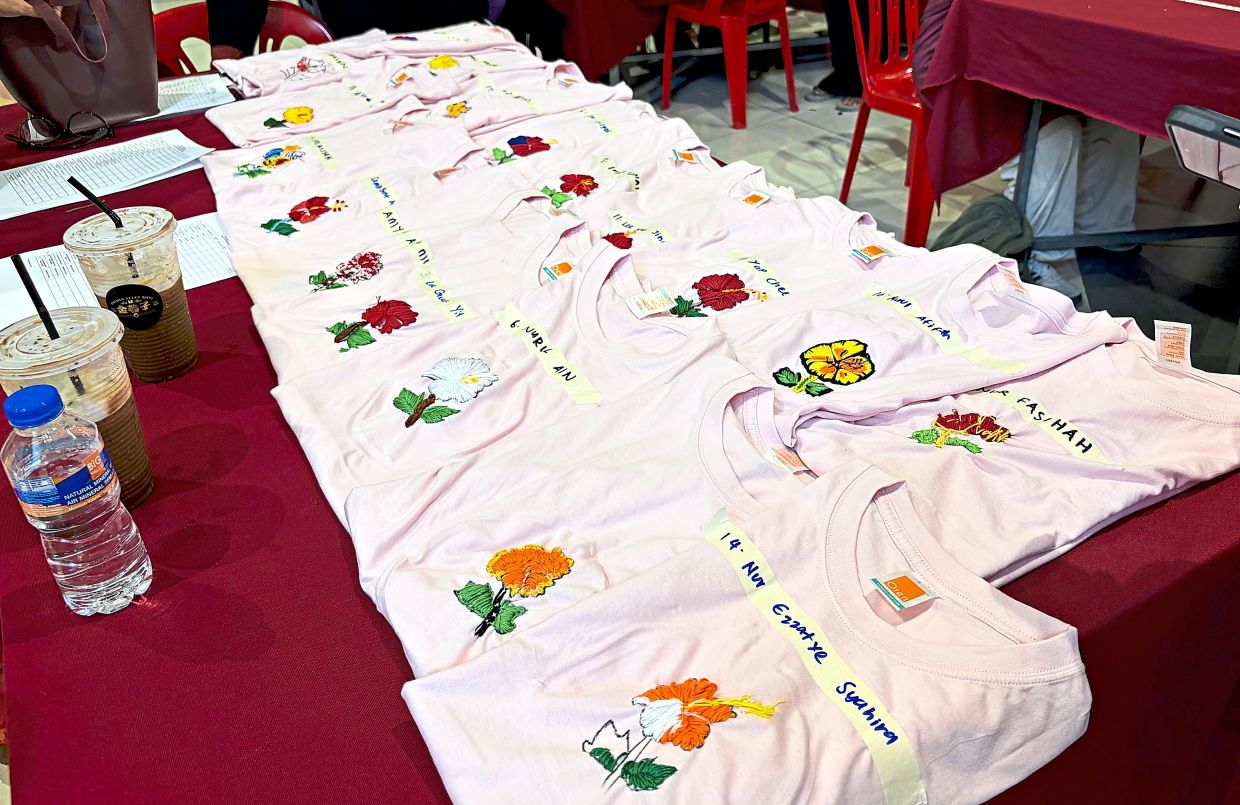 Some of the finished products of embroidered hibiscus flowers on T-shirts.