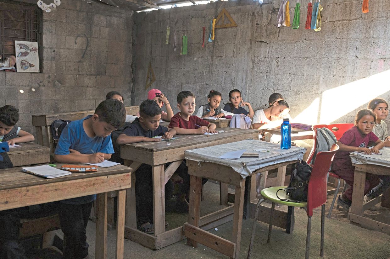 Children attending class in Gaza City. Classrooms are improvised, since many schools are still sheltering people displaced by the war. — Saher Alghorra/The New York Times