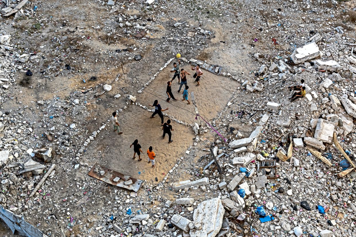 Children playing volleyball amid the rubble in Gaza City. — Saher Alghorra/The New York Times