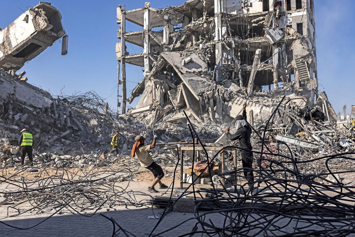 Workers straightening iron rods extracted from the rubble of destroyed buildings in Gaza City, which will be used to make frames for tents, beds and other things. — Saher Alghorra/The New York Times
