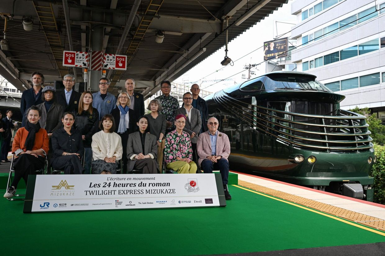 (From left, front) Barbery, French writer Claire Berest, Japanese writer Machi Tawara, Japanese writer Mariko Asabuki, Japanese author Anna Ogino, and French writer Paul Fournel. (From left, middle) Japanese writer Hitonari Tsuji, Japanese novelist Hitomi Kanehara, Writing in Motion founder Anne Forrest-Wilson, Japanese author Kaori Ekuni, and French poet Frederic Forte. (From left, rear) French writer Christophe Ono-dit-Biot, Japanese poet Hisaki Matsuura, Argentine writer Eduardo Berti, French writer Herve Le Tellier, Japanese author Toh EnJoe, and French author Richard Collasse at Shin-Osaka station. — AFP