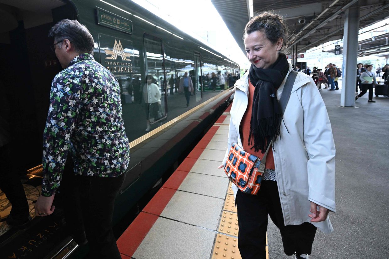Barbery boarding the Twilight Express Mizukaze after posing for a group photo at Shin-Osaka Station in Osaka Prefecture on Oct 22. — AFP