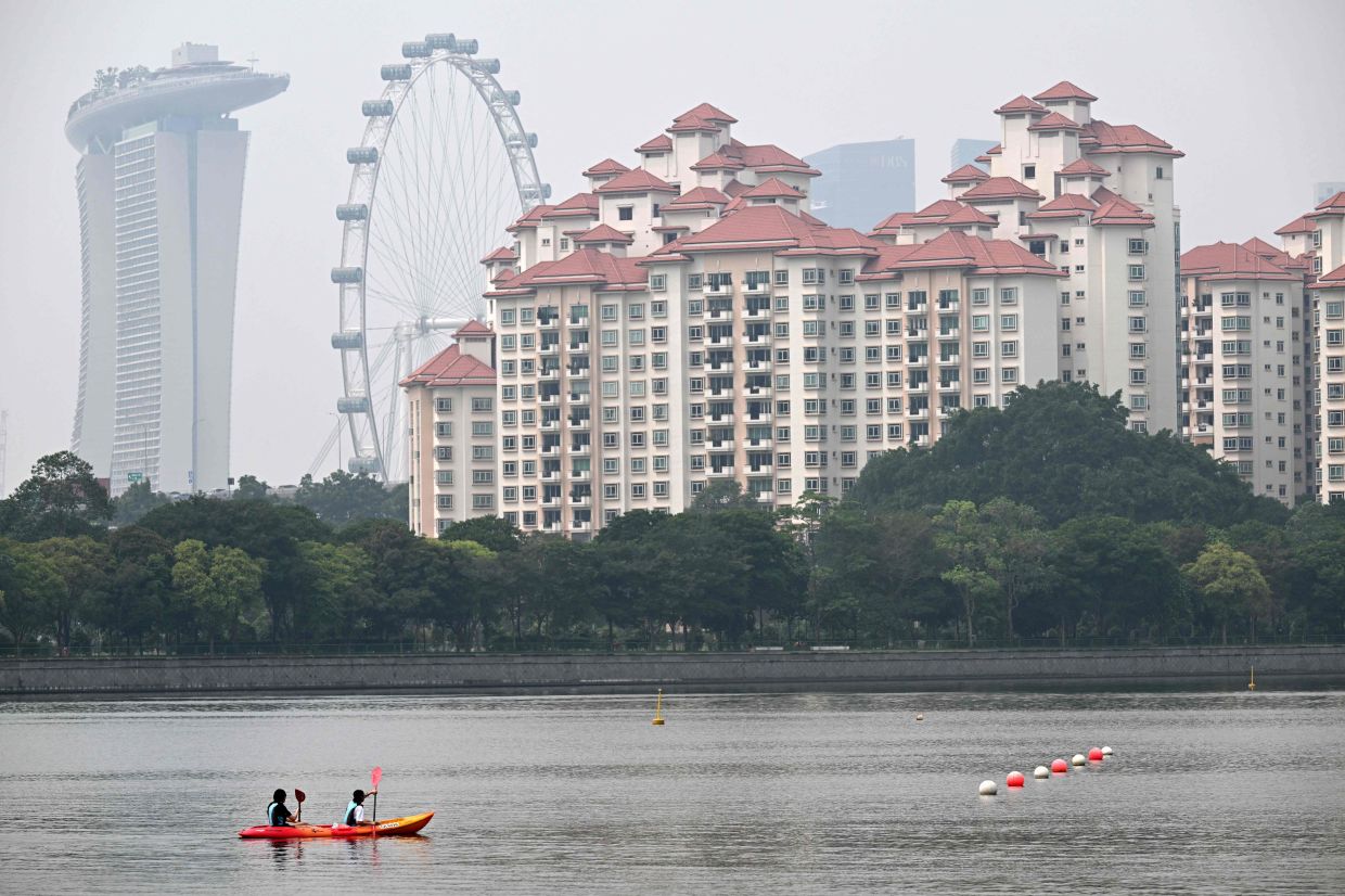 People row a canoe along the Kallang river as the haze eases in Singapore on Friday, October 23, 2026. -- Photo by Roslan RAHMAN / AFP)