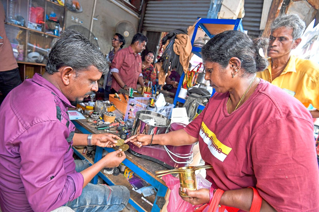 A customer getting her murukku ‘achi’ fixed at the repair shop in Jalan Tengku Kelana, Klang, in the lead-up to the festival.