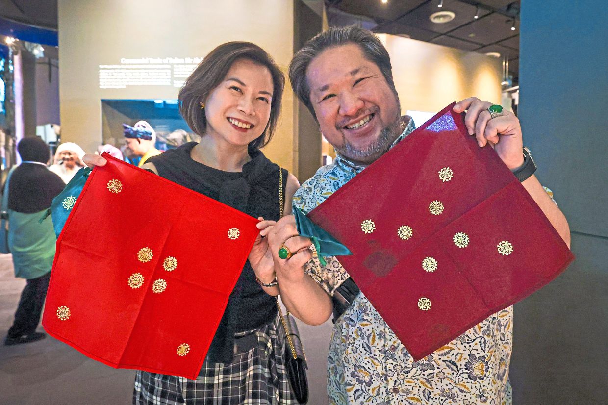 Tham (right) and his partner showing their finished telepuk artwork after attending the workshop.