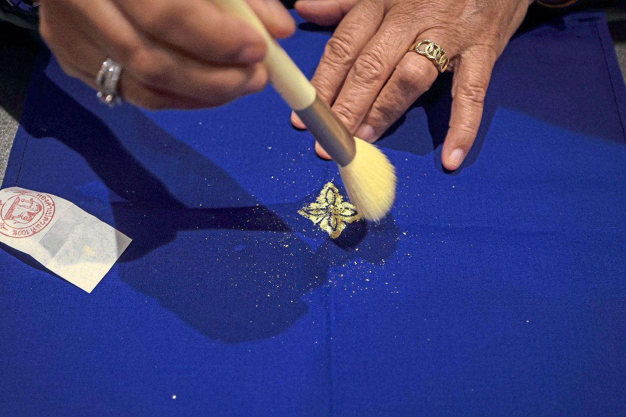 Gold leaf is applied to the area coated with gum, before the excess is brushed away to reveal the floral motif.