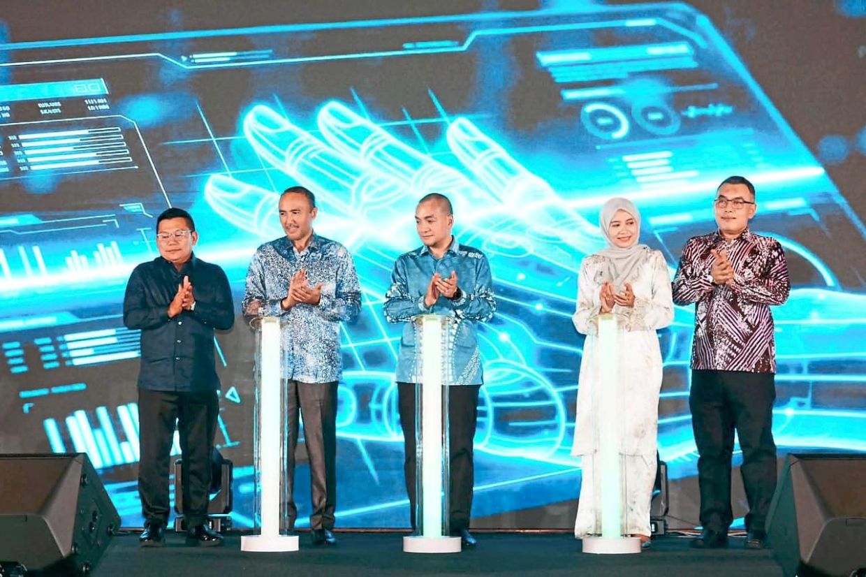 Onn Hafiz (centre) flanked by Mohd Jafni (left) and Suhailizan at the launch of a housing aid programme in Johor Baru. — Handout