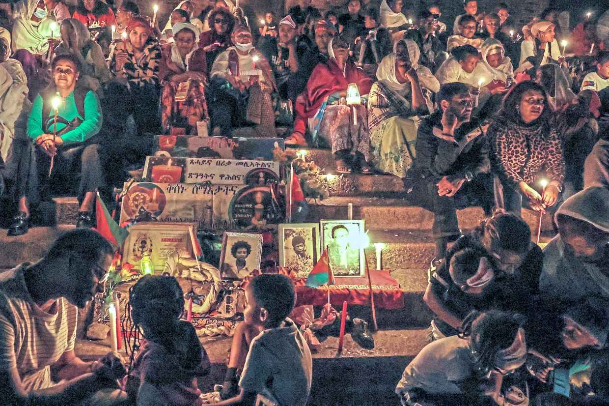 People sitting as they hold candles during a vigil ahead of Martyrs’ Day, which commemorates the sacrifices made by Eritreans who lost their lives during the Eritrean War of Independence, in Asmara. — Reuters