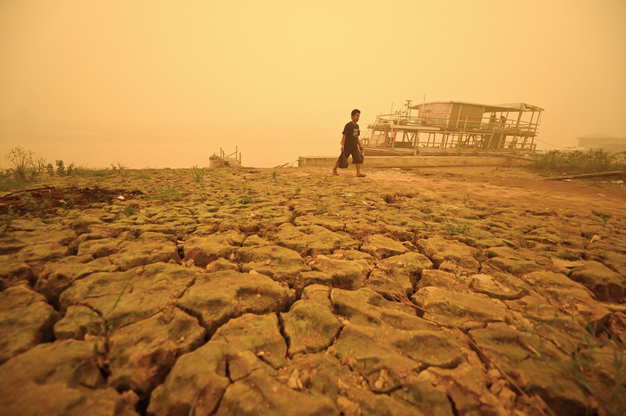 A man walks back home in a village amid thick haze from wildfires in Palangkaraya, Central Kalimantan, Indonesia, on Saturday, Oct. 24, 2026. -- AP Photo/Yulianus Stefan Lundju