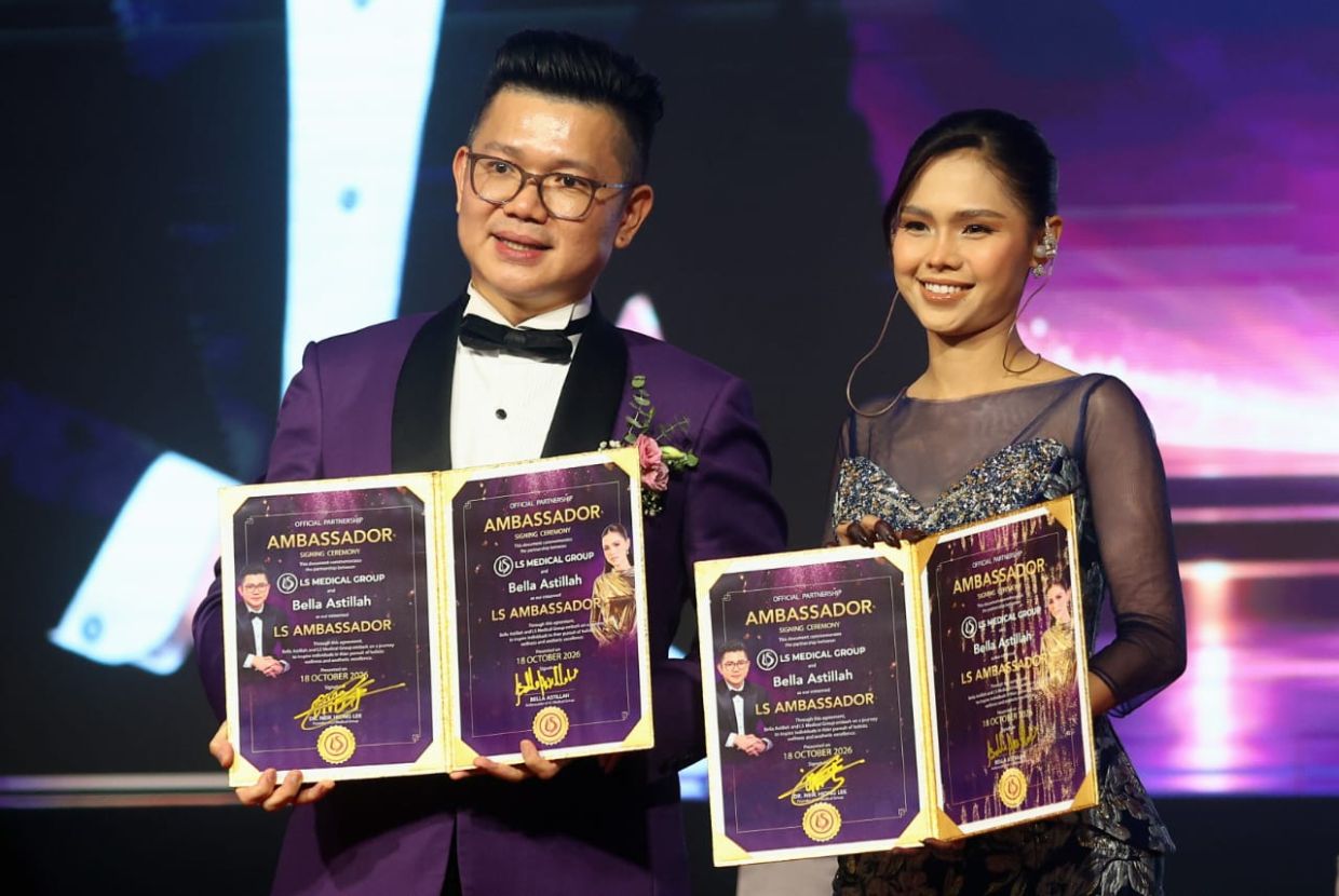 Dr Neik (left) and Bella (right) presenting the brand ambassador agreement signed by both parties, marking Bella’s appointment as the LS Medical Group’s second brand ambassador.—RONNIE CHIN/The Star