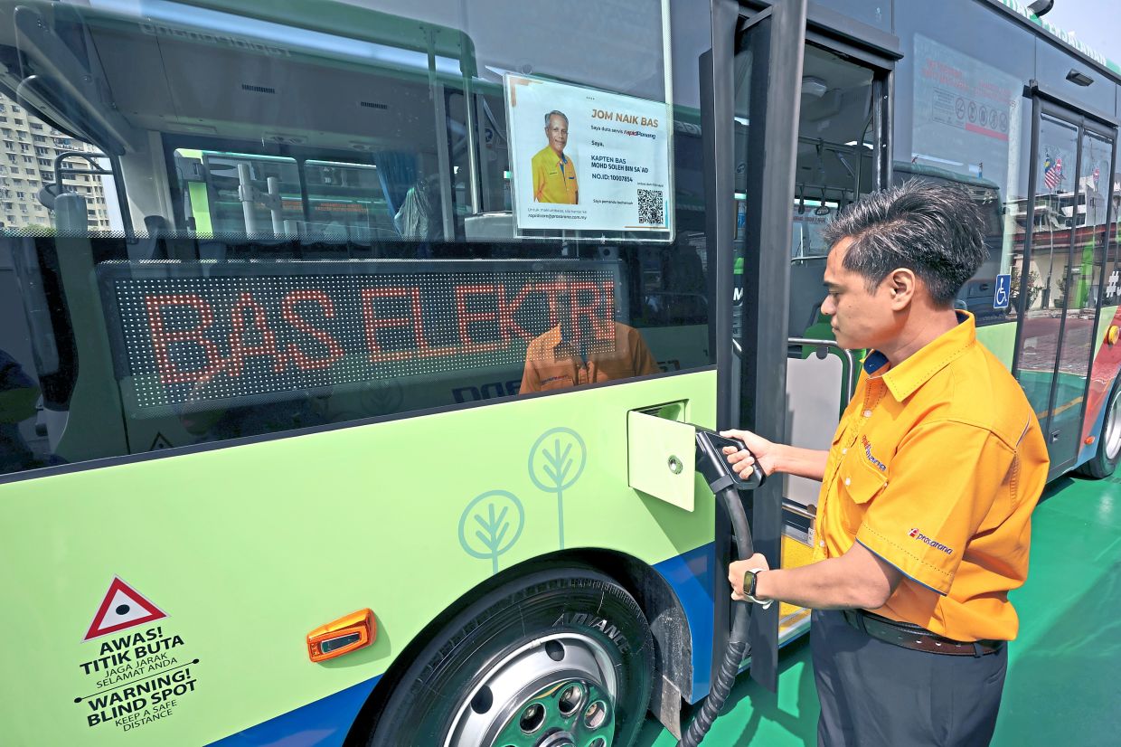A bus driver charging a newly introduced Rapid Penang electric bus at the bus depot in Pengkalan Weld.