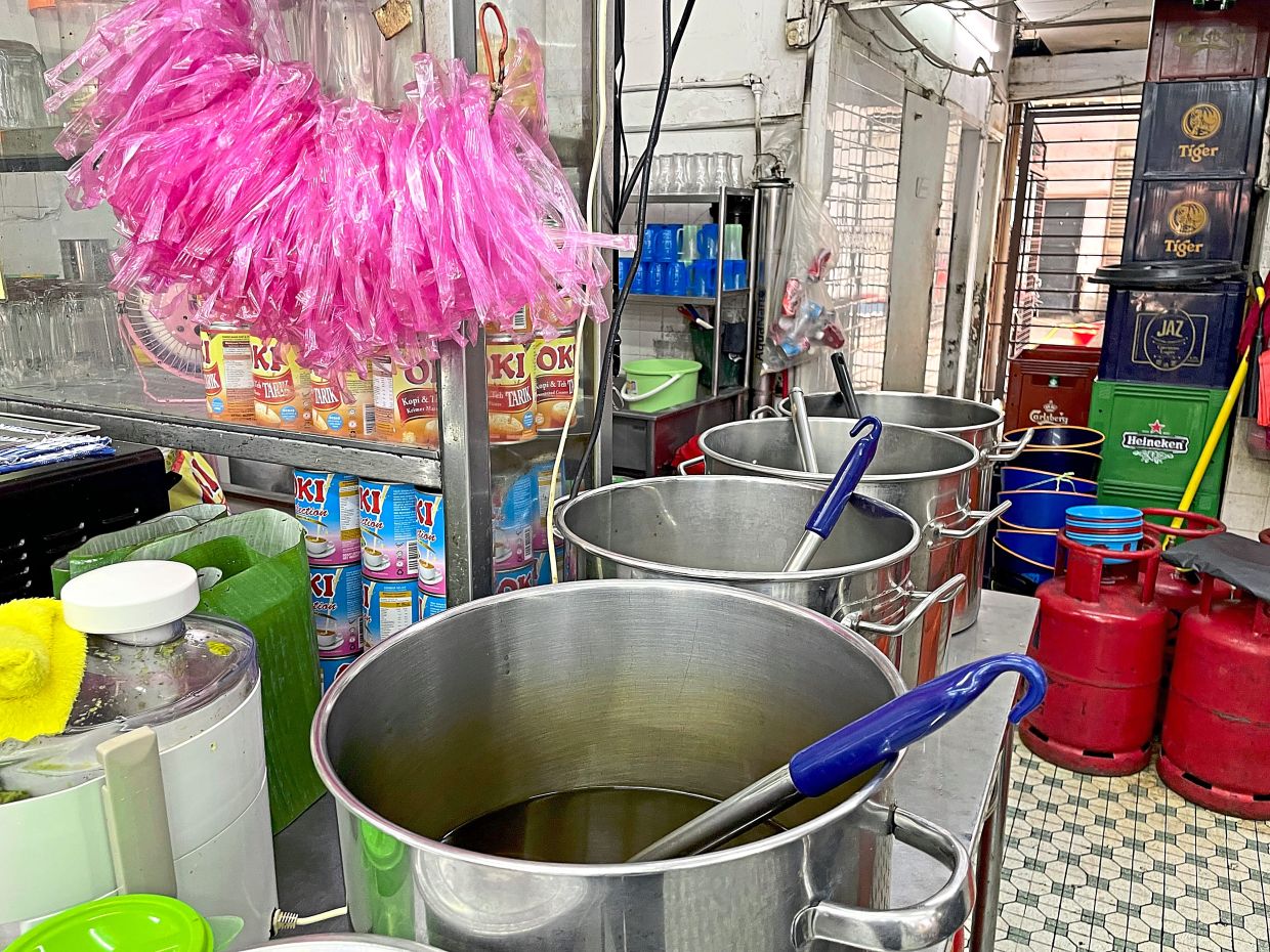 Large stainless-steel pots containing soup left uncovered on the counter which is near the toilet of an eatery in Pudu.