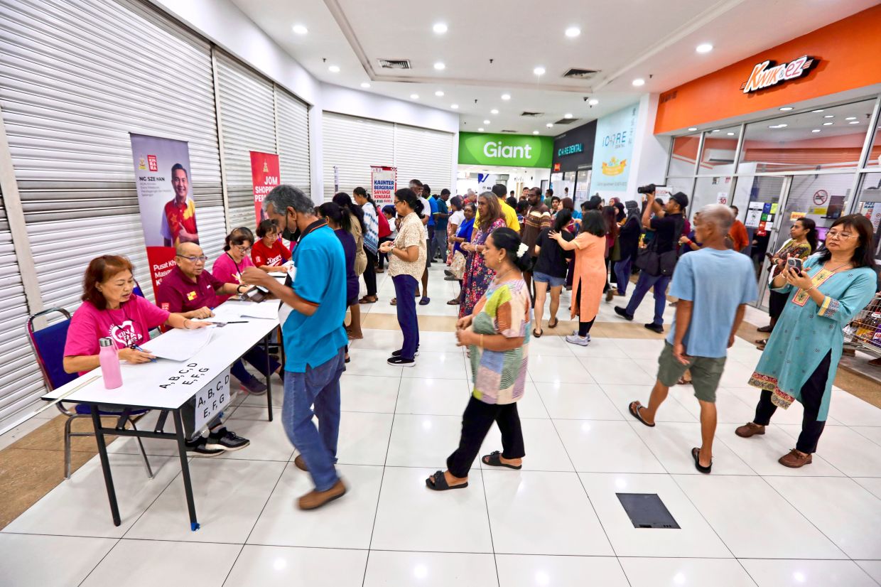 Beneficiaries redeeming their Deepavali vouchers (left) while some check their status for the ‘Sumbangan Tunai Rahmah’ scheme at the Inland Revenue Board counter (back). — LOW LAY PHON/The Star