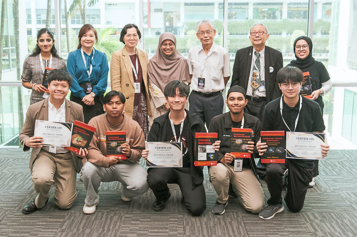 Ng (front row, left) and Khoo (front row, middle) in a group photo at the National Physics Conference 2025.