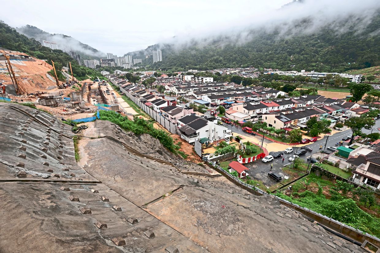 Deadly slope: A doctor was killed after a landslide crashed into the back of his house. — ZHAFARAN NASIB/The Star