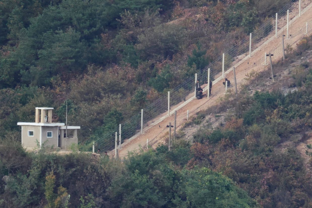 North Korean soldiers resting near a newly set up barbed wire fence along their border are seen in this picture taken from an observation deck in Gimpo, South Korea, on Monday, October 26, 2026. REUTERS/Kim Hong-Ji