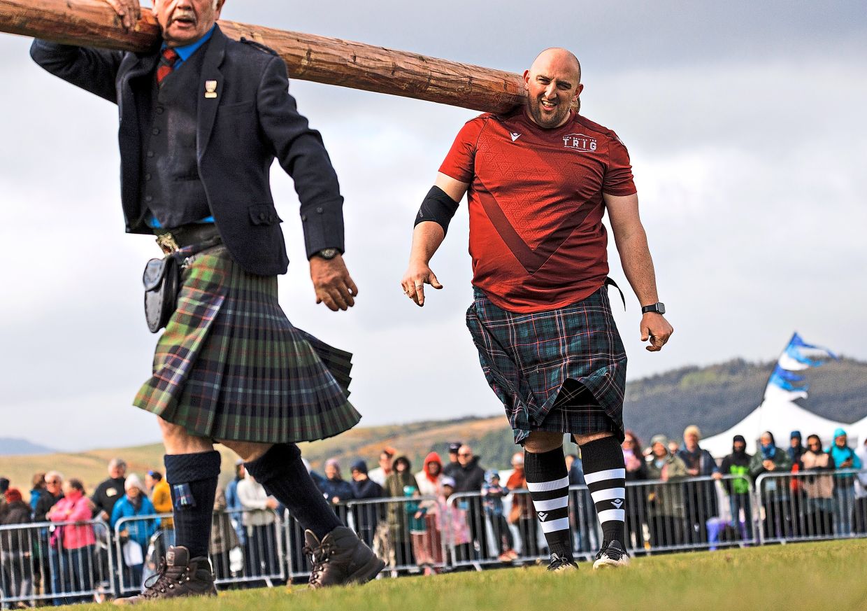 The caber is taken off the field during the caber toss event at the Highland Games in Gourock, Scotland.