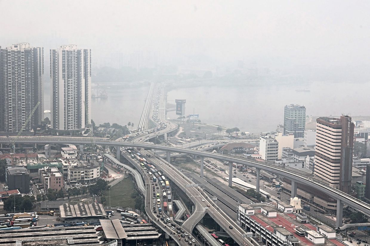 A hazy skyline of the Johor Causeway overlooking Singapore.