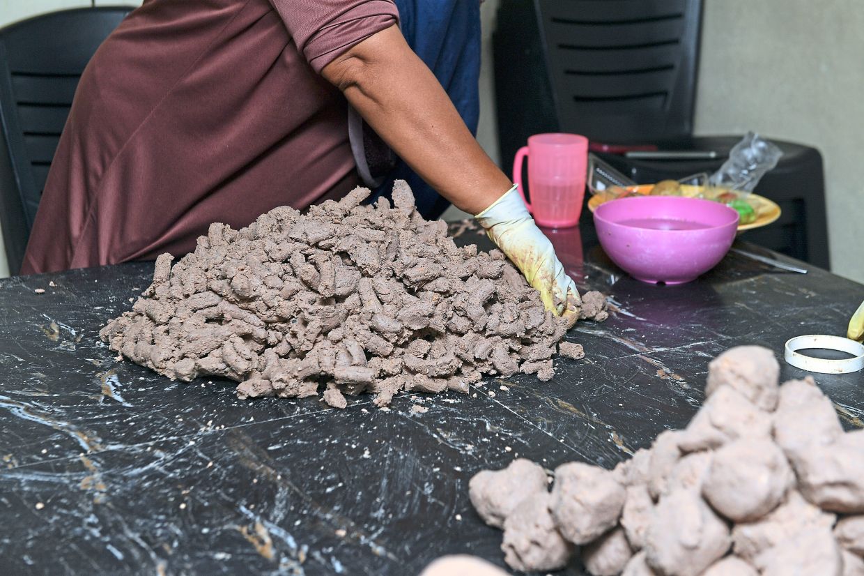 Belacan being manually shaped into bricks at HM Belacan in Kuala Perlis.