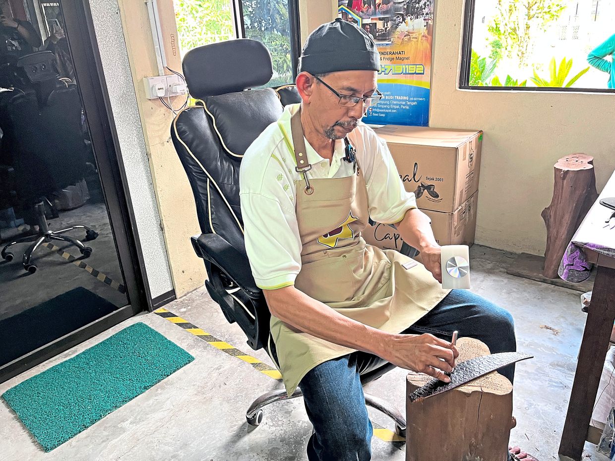 Saad (left) showing how he presses patterns into leather in the handcrafting of the traditional ‘capal’.