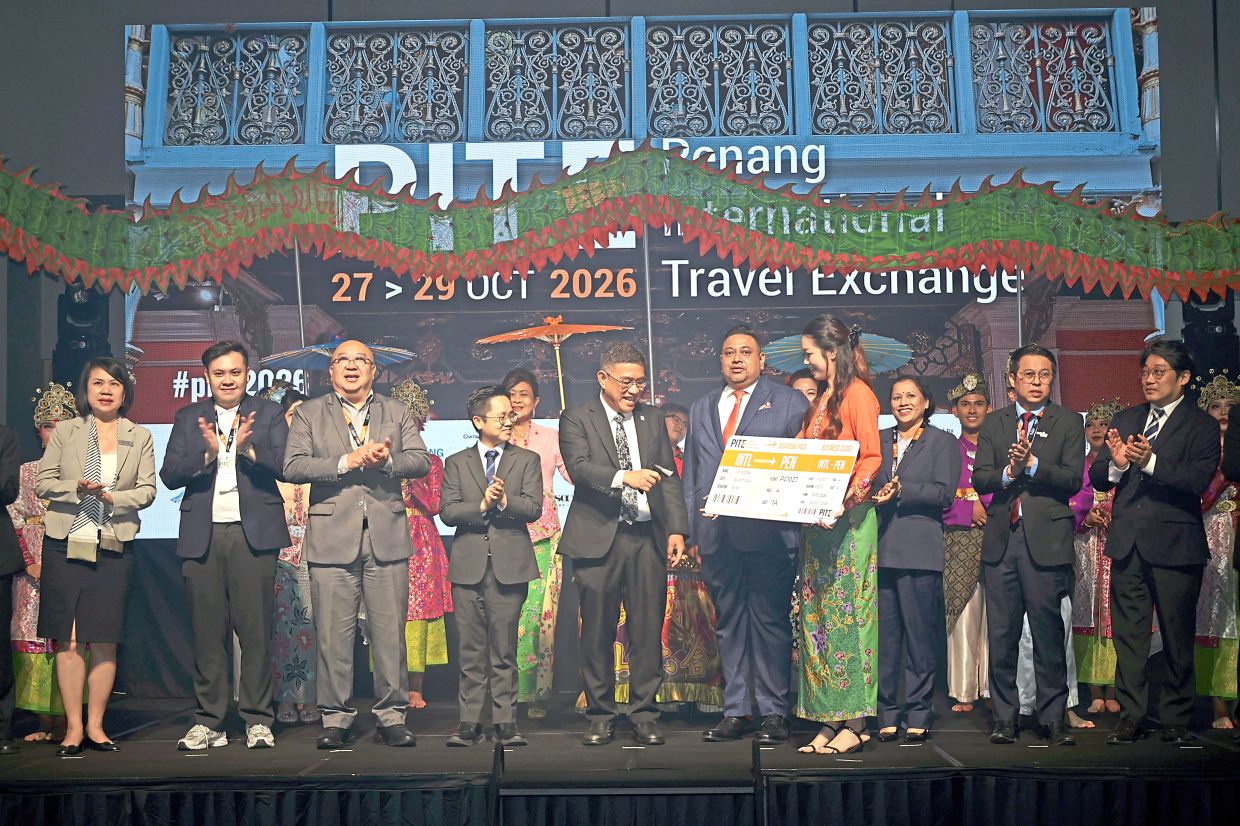 Hon Wai (fifth from left) scanning a mock boarding pass to open Penang International Travel Exchange 2026 in George Town.