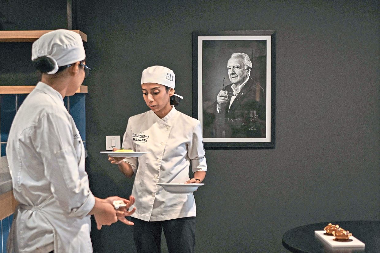 On the job: Student chefs carrying dishes at Ecole Ducasse. — AFP