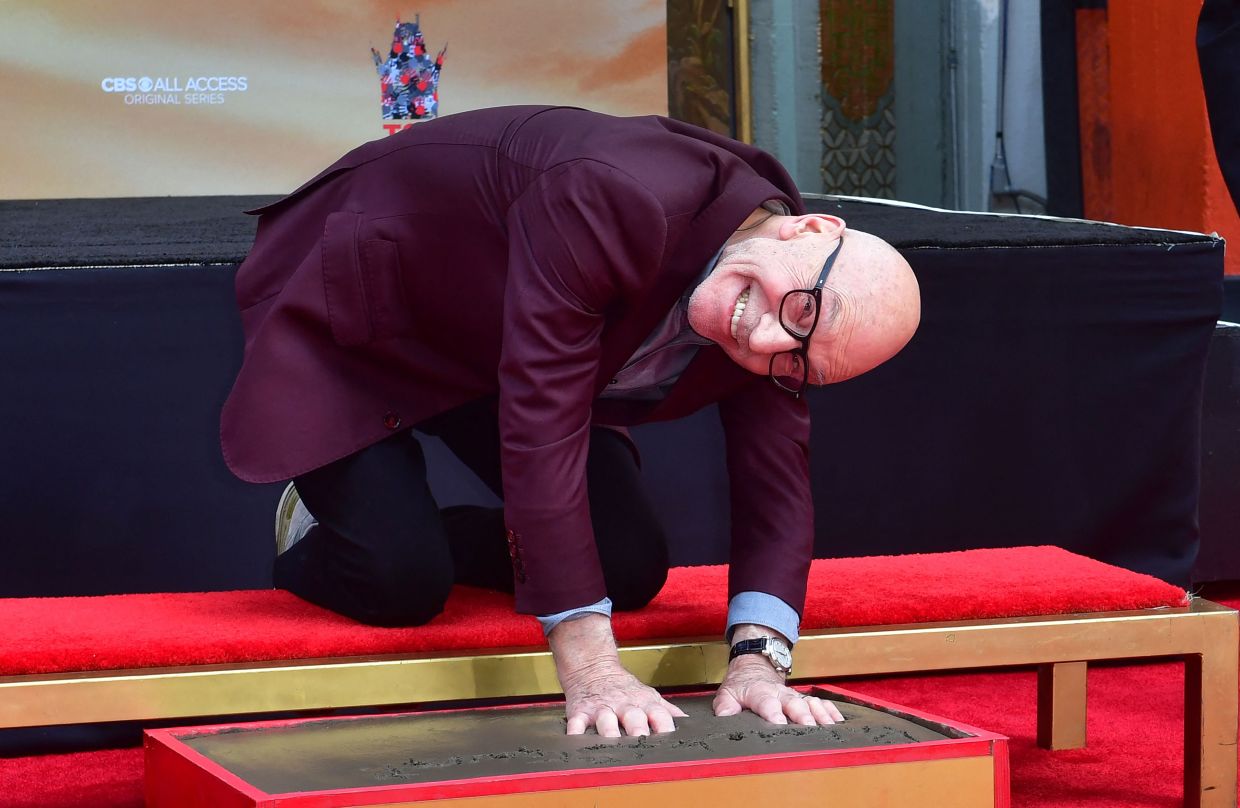 Patrick Stewart poses as he places hands in the block of cement during his Hand and Footprints ceremony at the TCL Chinese Theater in Hollywood, California on January 13, 2020. Photo: AFP