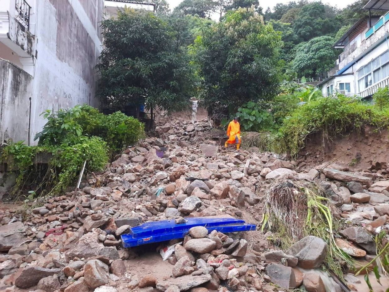 A worker walks through rocks and mud brought down by flash floods and a landslide that inundated roads in Patong, Kathu district, as authorities clear debris after heavy rain triggered flash floods and mudslides, in Phuket, Thailand Oct 26, 2026. - Photo: Phuket Provincial Public Relations Office/Handout via Reuters