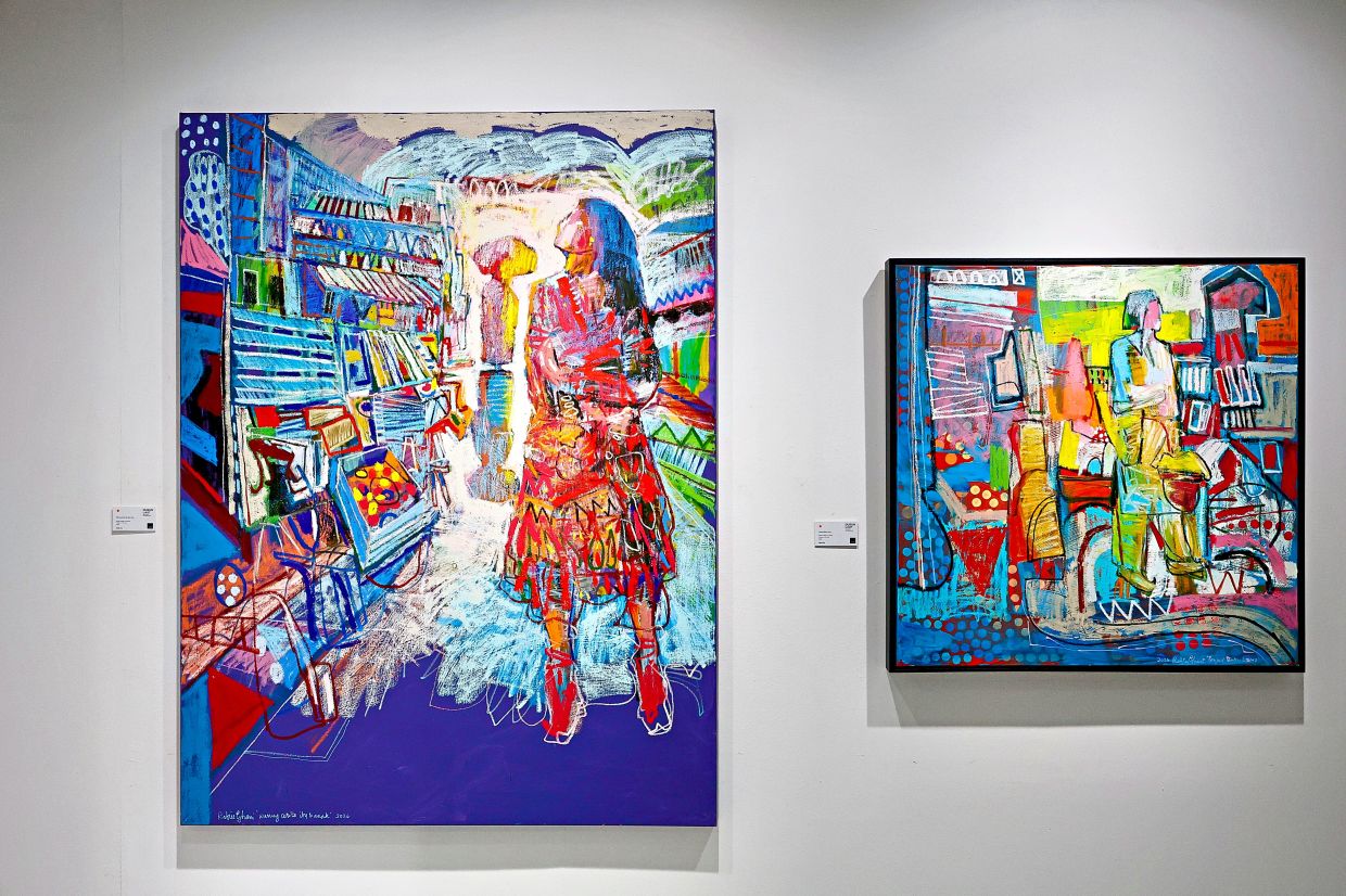 Rafiee’s paintings 'Warung Cerita Ibu Dan Anak' (left) and 'Penjual Buku Lama', a smaller work, draw on his visit to an isolated island with a small second-hand bookstore serving local residents. Photo: The Star/Faihan Ghani