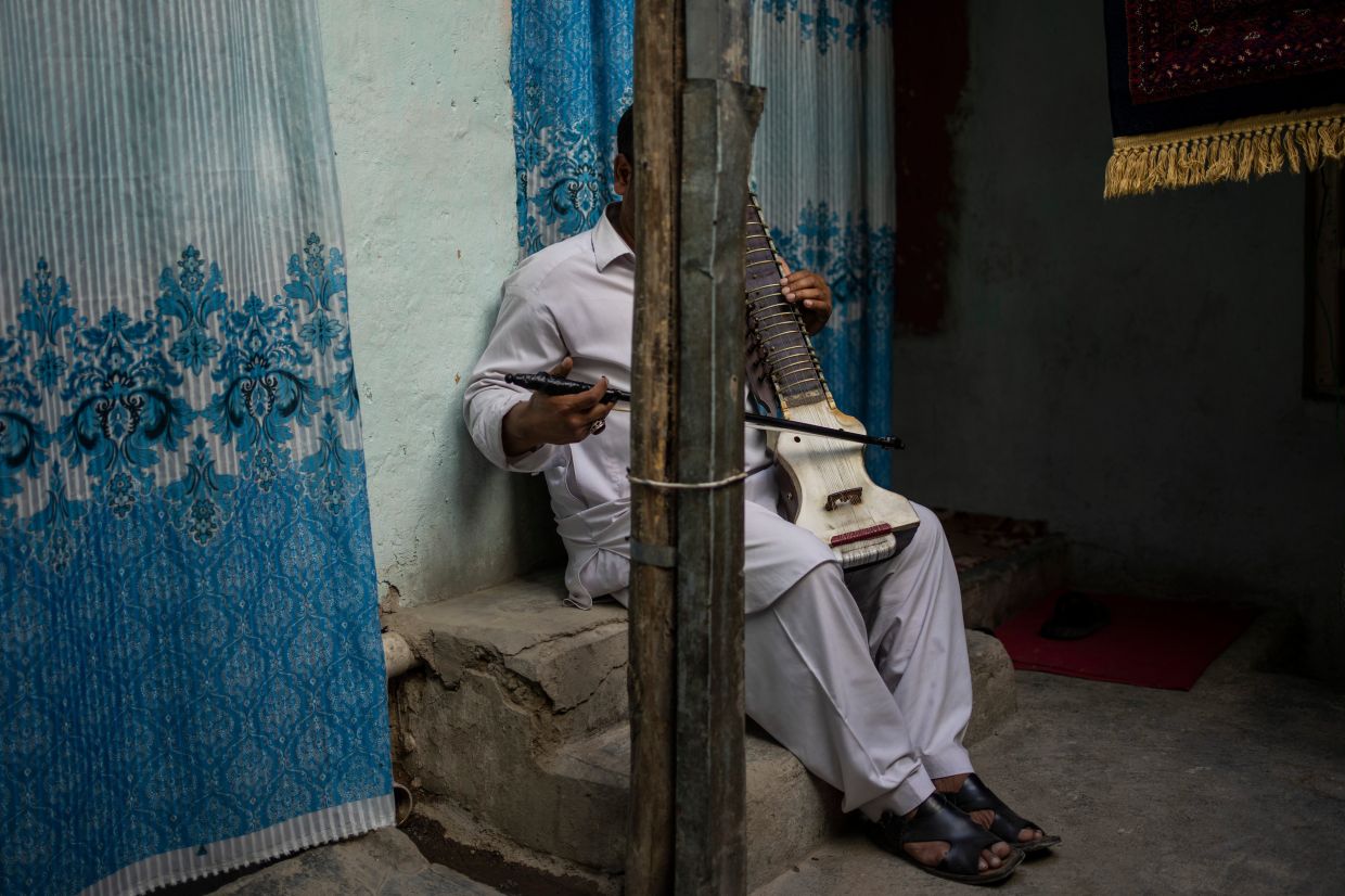 An Afghan musician poses for a portrait with his dilruba (a bowed string instrument) in Kabul. Photo: AP