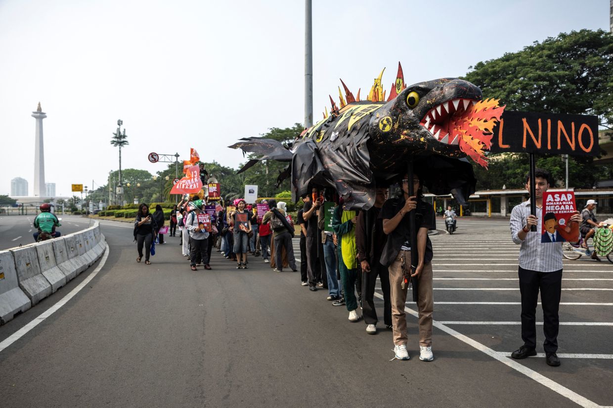Activists carrying a 'Godzilla El Niño' effigy march past the National Monument (Monas) complex during a rally urging the government to take more action to address the climate crisis and forest fires across the country, outside the US Embassy in Jakarta, Indonesia, on Friday, October 30, 2026. -- Photo: REUTERS/Willy Kurniawan
