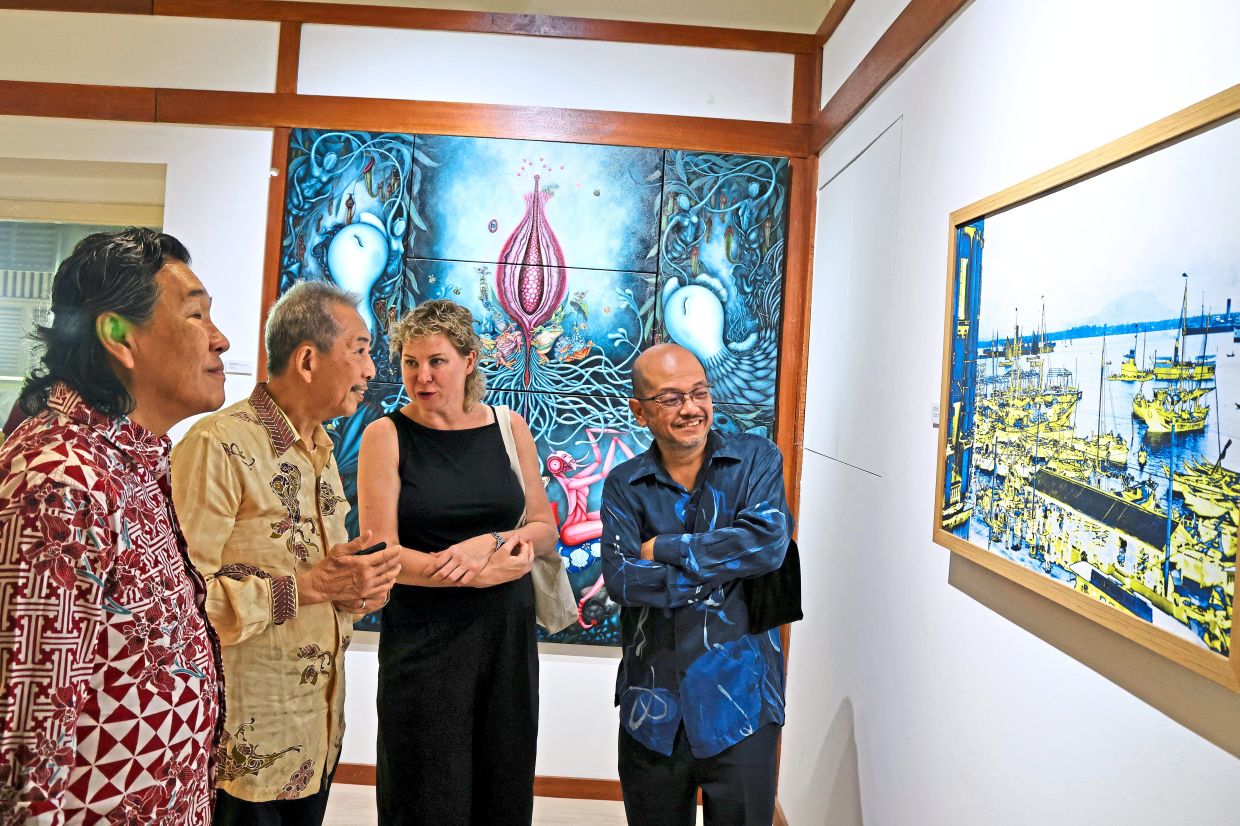 Visitors admiring a painting by Choy Khye Fatt (second from left) on display at the Penang State Museum branch in Jalan Macalister.