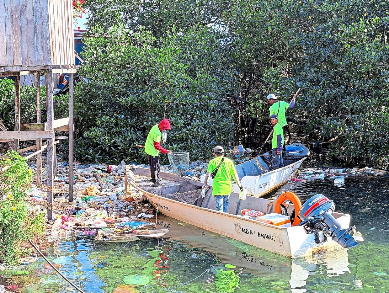 Volunteers and villagers collecting rubbish from Kampung Sri Aman in Semporna, Sabah. Community-led initiatives and NGOs are proving that sustained solutions in waste management are achievable. — Filepic