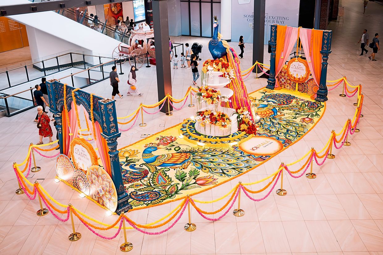 A large blue peacock sits above a sprawling kolam at IOI Mall Damansara. — Handout