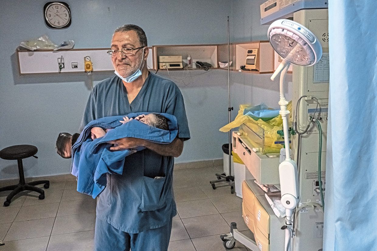 A doctor holding a newborn baby, Fares Al Samra, at Jabal Amel Hospital in Tyre, in the aftermath of Israeli strikes in June. — Daniel Berehulak/The New York Times