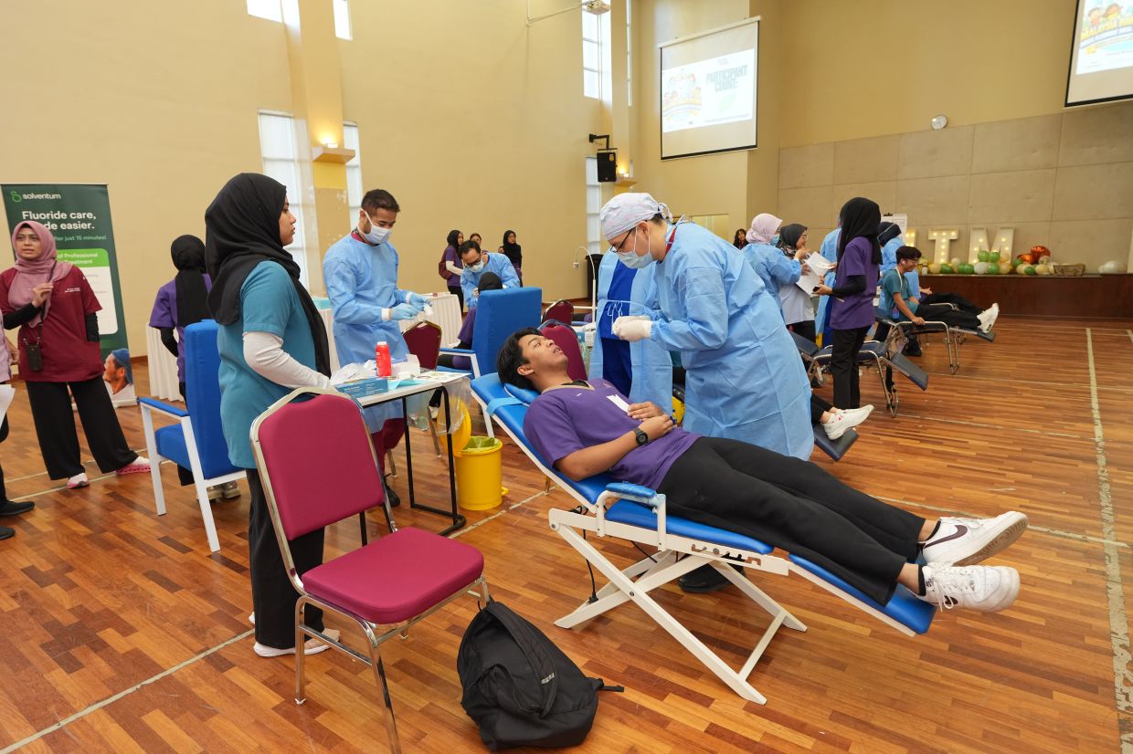 Dental professionals and postgraduate practitioners from UiTM provide topical fluoride applications to participants, supported by Solventum’s corporate social responsibility initiative to promote preventive oral healthcare within the community.