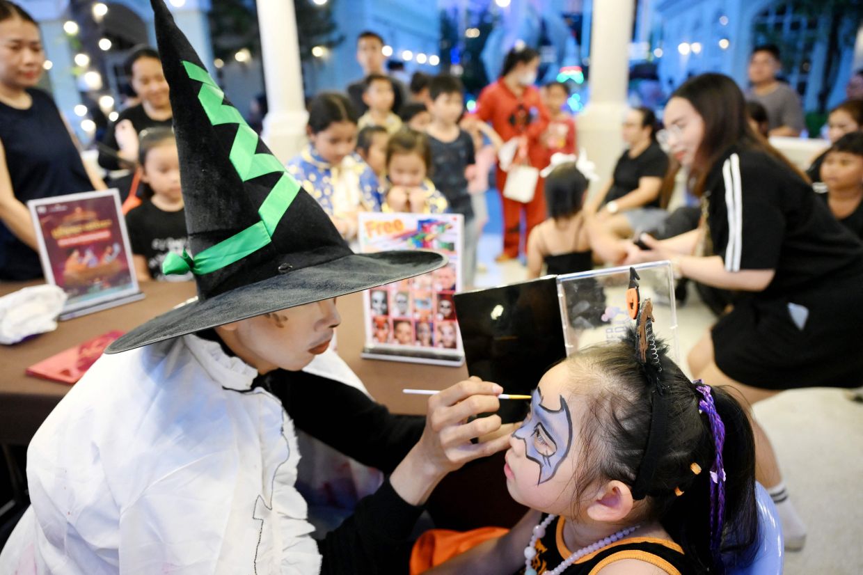 Mothers paint their children's faces during a Halloween event at Euro Park inside the Peng Huoth development in Phnom Penh on Saturday, October 31, 2026. -- Photo by TANG CHHIN Sothy / AFP